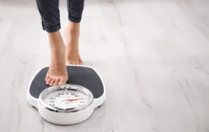 Bare feet standing on a dial bathroom scale