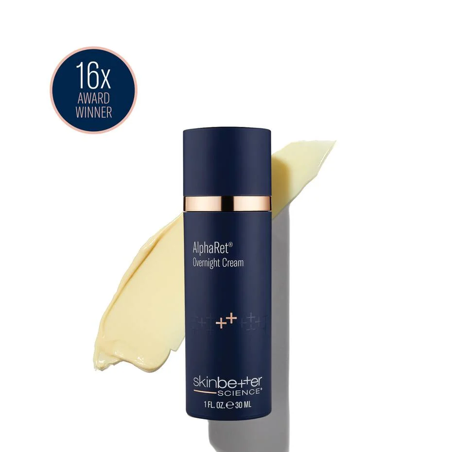 A navy skinbetter science AlphaRet Overnight Cream bottle on a white background, beside a pale yellow cream swatch and a “16x Award Winner” roundel.